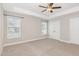 Bright bedroom featuring plush carpeting, a ceiling fan, and a double door closet at 503 Gateway Townes Blvd, Wake Forest, NC 27587