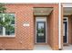 A detailed shot of a brick porch, showing the front door and window of a townhome with white trim at 503 Gateway Townes Blvd, Wake Forest, NC 27587