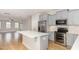 An open-concept kitchen with stainless steel appliances, gray cabinets, and a large island open to living area at 503 Gateway Townes Blvd, Wake Forest, NC 27587