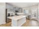 A modern kitchen with stainless steel appliances, light gray cabinets, and a center island with a white countertop at 503 Gateway Townes Blvd, Wake Forest, NC 27587