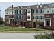 Modern townhomes with brick and siding exteriors, landscaping, and sidewalks at 503 Gateway Townes Blvd, Wake Forest, NC 27587
