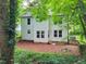 Back exterior view with many windows, a wooden fence and a large landscaped yard at 5105 Carolwood Ln, Durham, NC 27713