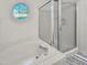 Bright bathroom featuring a bathtub with a glass shower door and a round window at 5105 Carolwood Ln, Durham, NC 27713