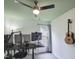 Bedroom setup as a home office featuring a ceiling fan, desk with monitors, and hanging guitar at 5105 Carolwood Ln, Durham, NC 27713