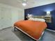 Comfortable bedroom with a modern accent wall, ceiling fan, and lighting at 5105 Carolwood Ln, Durham, NC 27713