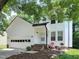 Charming two-story home with white siding, a front-facing garage, and lush greenery at 5105 Carolwood Ln, Durham, NC 27713