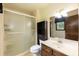 Well-lit bathroom features a shower, vanity with sink, and storage shelves at 523 Edwards Rd, Henderson, NC 27537