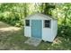 A white and blue shed in the backyard with a ramp and two windows at 523 Edwards Rd, Henderson, NC 27537