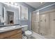 Bathroom with wood cabinets, large vanity mirror, and shower at 5405 Swordsman Ct, Knightdale, NC 27545