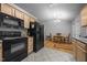 Kitchen with black appliances, wood cabinets and view to the dining area at 5405 Swordsman Ct, Knightdale, NC 27545