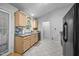 Bright kitchen with wood cabinets, black appliances, and a window over the sink at 5405 Swordsman Ct, Knightdale, NC 27545