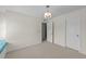 Neutral bedroom featuring carpet, a stylish chandelier and a door to the closet at 5545 Moneta Ln, Apex, NC 27539