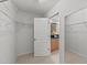 Walk-in closet leading into a full bathroom with dual sinks and granite countertops at 5545 Moneta Ln, Apex, NC 27539
