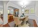 Elegant dining room with modern lighting, wainscoting, and views into the kitchen, perfect for entertaining guests at 5545 Moneta Ln, Apex, NC 27539