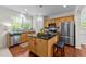 Well-lit kitchen featuring stainless steel appliances, a center island, and wood cabinetry, offering style and functionality at 5545 Moneta Ln, Apex, NC 27539