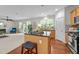 Bright kitchen boasts a large island with seating, wood floors, stainless steel appliances, and plenty of natural light at 5545 Moneta Ln, Apex, NC 27539
