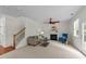 Spacious living room with fireplace, ceiling fan, staircase, and a comfortable seating area at 5545 Moneta Ln, Apex, NC 27539