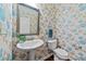 Charming powder room featuring floral wallpaper, a pedestal sink, and a decorative mirror, creating a unique space at 5545 Moneta Ln, Apex, NC 27539