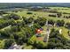 Idyllic aerial view showcasing a home bordered by mature trees and a serene pond, creating a private and picturesque setting at 567 E Ridge Ave, Liberty, NC 27298