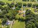 An aerial shot showcases a property's boundary on a generous lot bordering mature trees, and a pond in a quiet neighborhood at 567 E Ridge Ave, Liberty, NC 27298