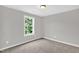 This bedroom features carpet floors, a ceiling light, and a window that provides ample natural light at 567 E Ridge Ave, Liberty, NC 27298