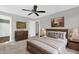 Cozy bedroom with carpet floors, ceiling fan, complete with bed, nightstands, lamps, artwork, and dresser with mirror at 567 E Ridge Ave, Liberty, NC 27298