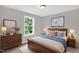 Bedroom complete with a wood bed and dressers, two lamps, artwork, a ceiling light, carpet, and a large window at 567 E Ridge Ave, Liberty, NC 27298