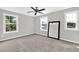 This bedroom features carpet floors, a ceiling fan, three windows that provide ample natural light, and a full length mirror at 567 E Ridge Ave, Liberty, NC 27298