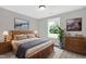 Bright bedroom features wood furnishings, cozy decor, and a large window with a view of the trees outside at 567 E Ridge Ave, Liberty, NC 27298