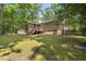 A house with a screened-in porch, wooden stairs, and a storage shed in a spacious, tree-filled backyard at 6009 Shadow Moss Cir, Raleigh, NC 27603