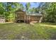 Exterior view of a home showcasing a screened-in porch, wooden stairs, and a spacious backyard at 6009 Shadow Moss Cir, Raleigh, NC 27603
