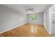 Bright bedroom features hardwood floors, gray walls, ceiling fan, and a window overlooking a green backyard at 6009 Shadow Moss Cir, Raleigh, NC 27603