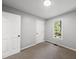 Bright bedroom features neutral carpet, gray walls, white trim, and a window overlooking a green backyard at 6009 Shadow Moss Cir, Raleigh, NC 27603