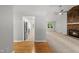 Open entryway into a living space showcasing a stone fireplace and a kitchen with stainless appliances at 6009 Shadow Moss Cir, Raleigh, NC 27603