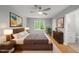 Stylishly staged main bedroom featuring modern furniture, decor, and a bright window with backyard views at 6009 Shadow Moss Cir, Raleigh, NC 27603