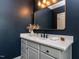 A stylish bathroom with blue walls, white quartz countertops, and a sleek mirror at 612 Peach Orchard Pl, Cary, NC 27519