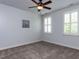 Neutral bedroom with carpet, a ceiling fan, and two windows providing natural light at 612 Peach Orchard Pl, Cary, NC 27519