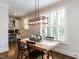 Bright dining room features wood table, modern light fixture, hardwood floors, and built in desk area at 612 Peach Orchard Pl, Cary, NC 27519