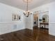 Dining room featuring hardwood floors, wainscoting, elegant lighting and seamless flow to other spaces at 612 Peach Orchard Pl, Cary, NC 27519