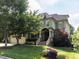 Inviting two-story home showcasing lush landscaping, stone accents, and a covered front porch at 612 Peach Orchard Pl, Cary, NC 27519