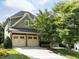 Charming home featuring a two-car garage, stone accents, and a well-manicured lawn at 612 Peach Orchard Pl, Cary, NC 27519
