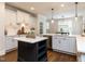 Bright kitchen with white cabinetry, a black island, stainless steel appliances, and hardwood floors at 612 Peach Orchard Pl, Cary, NC 27519