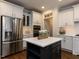 Modern kitchen island with white countertop, dark base, stainless steel appliances, and ample storage at 612 Peach Orchard Pl, Cary, NC 27519