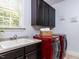 Laundry room with dark cabinets and red washer and dryer at 612 Peach Orchard Pl, Cary, NC 27519