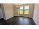 The dining room features hardwood floors and a modern chandelier, with windows overlooking the outdoors at 659 Bandon Aly, Cary, NC 27513