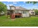 Backyard with green grass and deck, a screened-in porch and solar panels at 7 Teahouse Ct, Durham, NC 27707