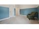 Well-lit bedroom with a chair near the window, open door, and two-tone walls at 7 Teahouse Ct, Durham, NC 27707