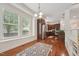 Sunlit dining area adjacent to the kitchen, featuring hardwood floors and large windows at 7 Teahouse Ct, Durham, NC 27707