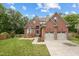 Traditional two-story brick home featuring an attached two-car garage and well-maintained lawn at 7 Teahouse Ct, Durham, NC 27707