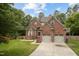Traditional two-story brick home featuring an attached two-car garage and well-maintained lawn at 7 Teahouse Ct, Durham, NC 27707
